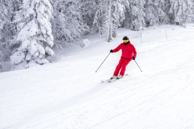 skier-ina-red-costume-skiing-down-slope-near-trees.jpg