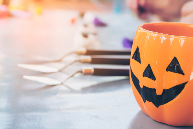 halloween-jack-o-lantern-face-mug-blurred-boy-sculpturing-clay-toy-background.jpg